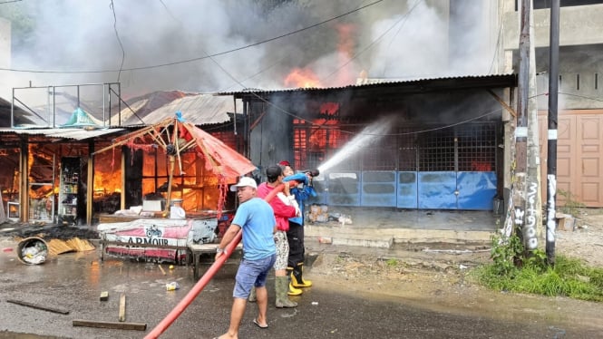 Petugas bersama warga berupaya padamkan api yang membakar 7 rumah di Kabupaten Simalungun.