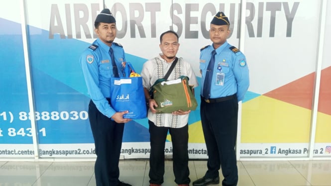 Petugas Avsec saat menyerahkan barang kepada pemiliknya yang tertinggal di Bandara Kualanamu.