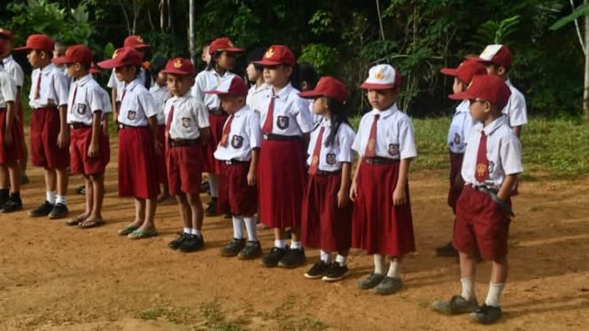 Pelajar SD Negeri 078481 Uluna’ai Hiligoo upacara di halaman sekolah.