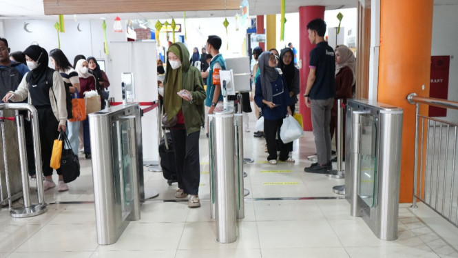 Aktivitas kedatangan penumpang kereta api di Stasiun Medan.