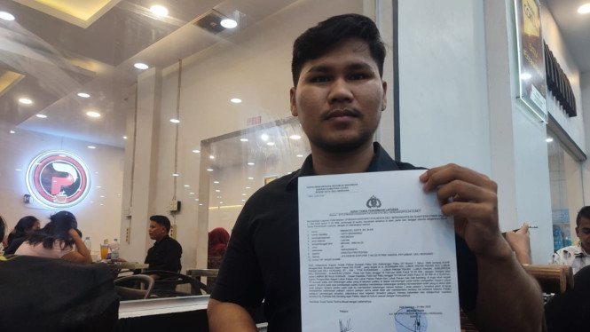 Gelora Butarbutar menunjukan surat pelaporan terhadap Lamria ke Polresta Deli Serdang.