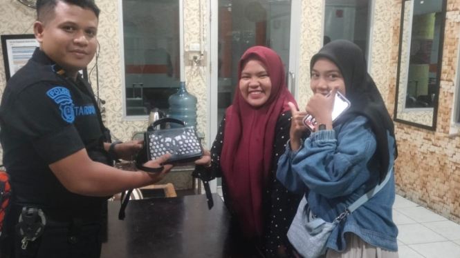 Petugas Keamanan KAI kembalikan barang tertinggal kepada penumpang.