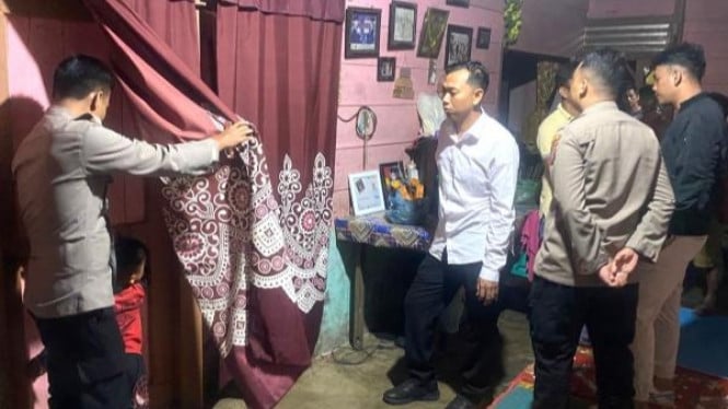 Petugas kepolisian saat berada di rumah dua yang disekap bapaknya.