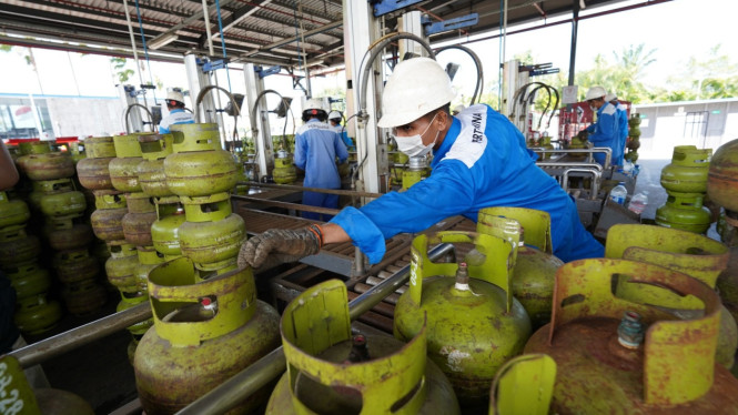 Petugas melakukan pengisian LPG 3 kg.