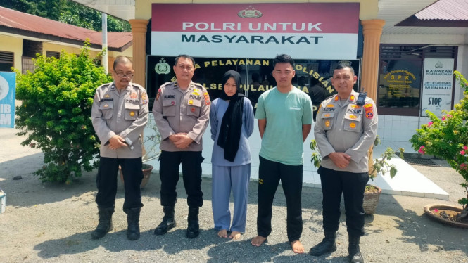 Orang tua bayi (tengah) saat diamankan Polsek Pulau Raja.