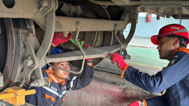Petugas KAI Sumut sedang melakukan pengecekan keamanan kereta api.