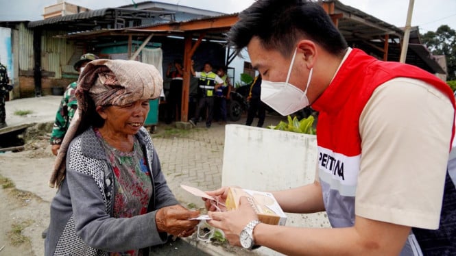Karyawan Pertamina Sumbagut Memberikan Masker Kepada Seorang Ibu, di Kabupaten Karo.