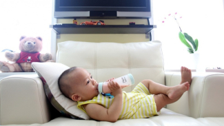 Ilustrasi anak minum susu melalui dot. Ilustrasi anak minum susu melalui dot.