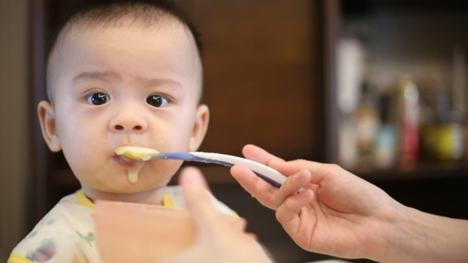 Ilustrasi bayi memakan makanan MPASI.