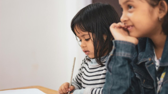 Dua anak belajar dengan fokus dan nyaman.