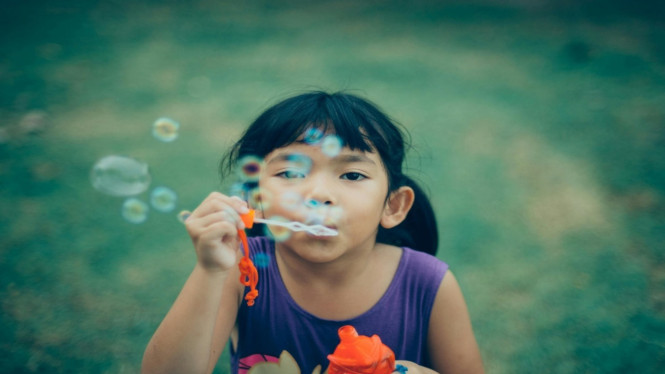 Ilustrasi seorang anak bermain balon di luar rumah