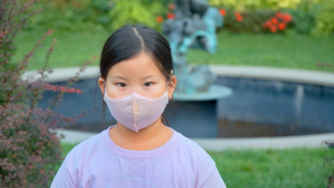 Anak menggunakan masker