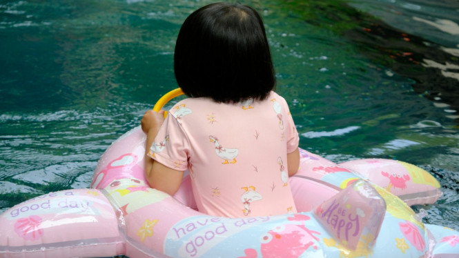 Anak berenang menggunakan pelampung