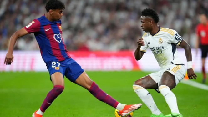 Lamine Yamal berebut bola dengan Vinicius Junior di laga  El Clasico.