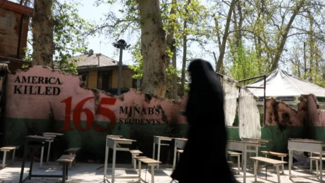 Seorang wanita Iran berjalan melewati monumen untuk anak-anak
