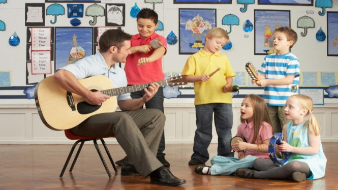 anak bermain alat musik bersama ayahnya