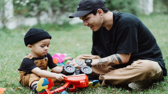 Ayah dan putranya bermain mobil-mobilan dihalaman rumah
