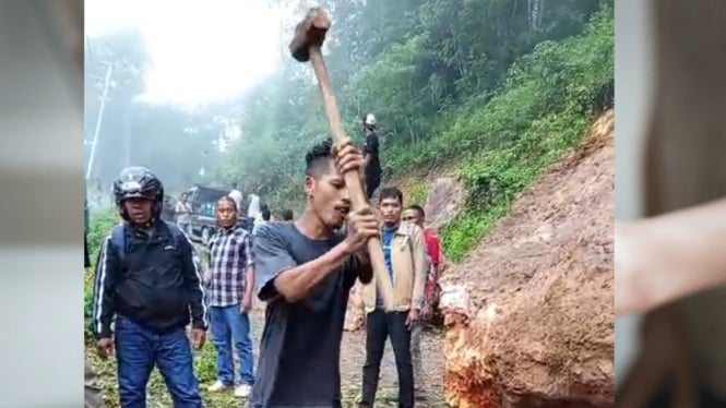 Bongkahan batu besar menutup badan jalan