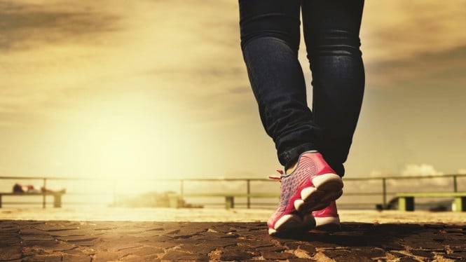 Seseorang dengan sepatu merah sedang berjalan.