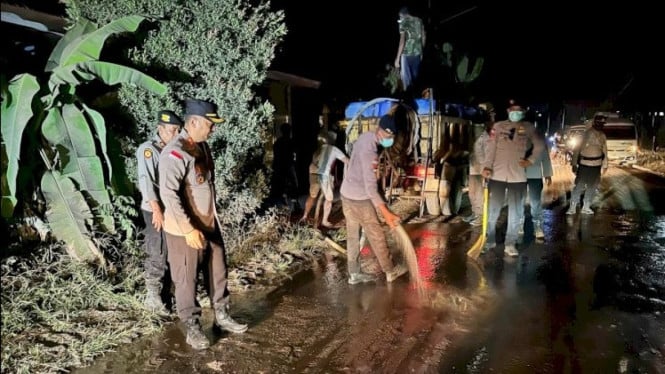 Kapolres Flores Timur, AKBP Adhytia Octorio Putra, memimpin kegiatan pembersihan jalan dari debu vulkanik pasca erupsi Lewotobi Laki-laki.