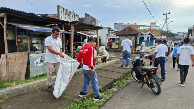 Karyawan Perumdam Tirta Komodo memungut sampah di depan Pasan Puni Ruteng.