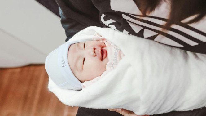 Bayi dalam pelukan ibunya.