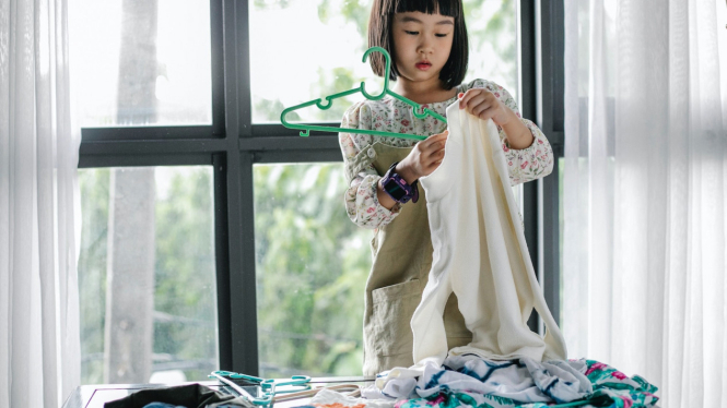 Ilustrasi anak membantu melipat baju