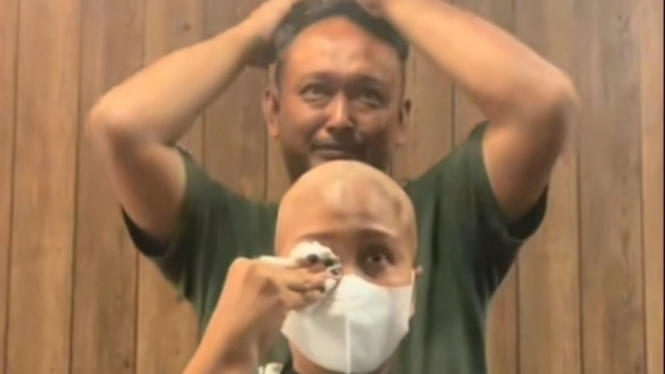 Suami yang sedang mencukur rambut istrinya karena sakit kanker