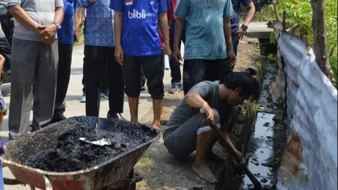 Warga si Padang sedang melakukan goro membersihkan saluran air.