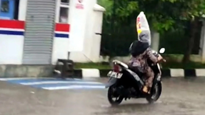 Emak-emak naik motor pakai plastik di kepala saat hujan