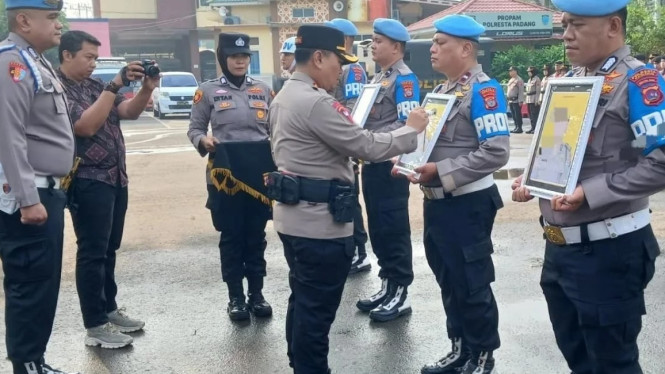 Kapolresta Padang Kombes Pol Apri Wibowo secara simbolis memberikan tanda silang pada foto mantan personel Polresta Padang yang mendapat sanksi PTDH,