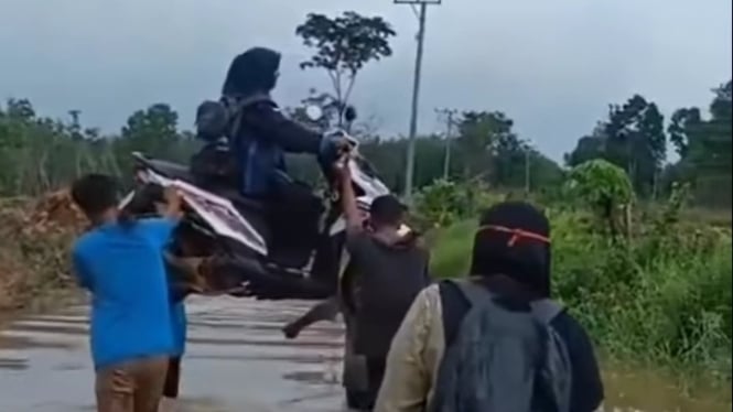 Guru digotong bersama motornya saat banjir