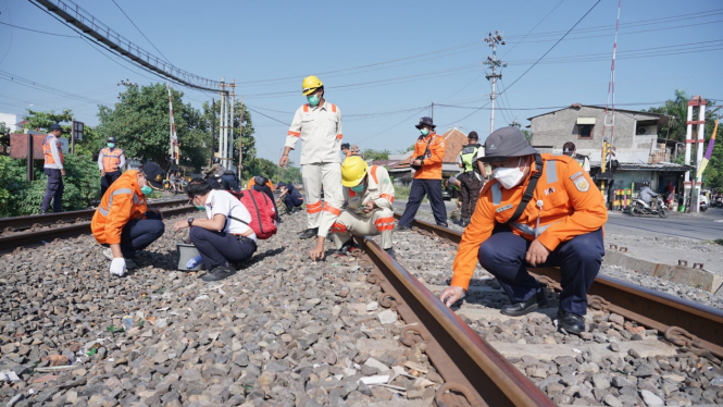 Petugas KAI bersihkan lintasan tepi rel kereta api