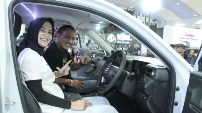 Yoyok Sukaw dan istri jajal kabin mobil listrik di GIIAS Semarang.