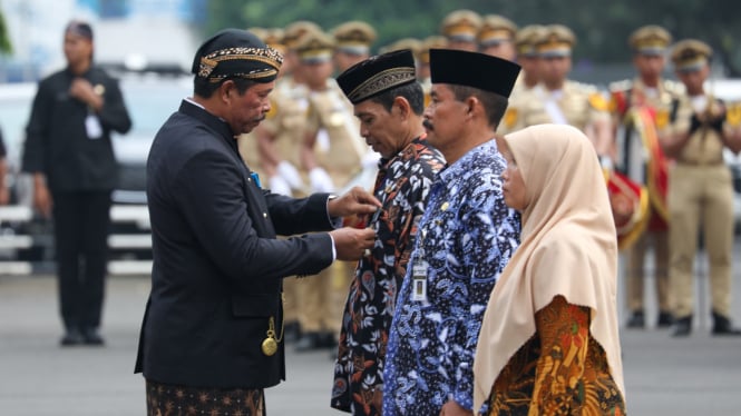 Pj Gubernur Jateng berikan tanda penghargaan guru.