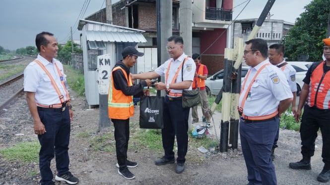 Petugas perlintasan rel kereta api mendapat bingkisan sembako.