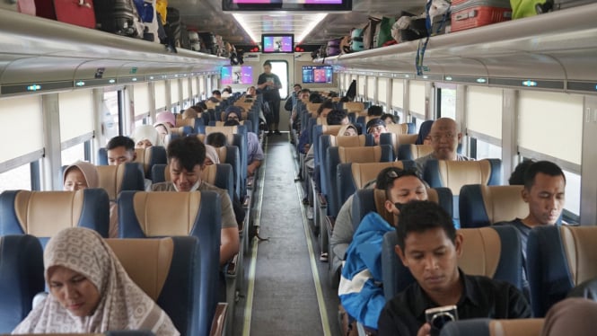 Penumpang menikmati perjalanan naik kereta api.