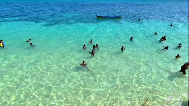 Keindahan pantai pasir putih dan laut biru tosca.