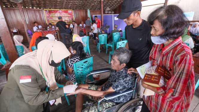Petugas kesehatan memeriksa warga di daerah terdampak rob.