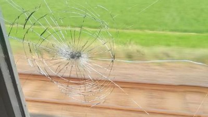 Kaca kereta api pecah terkena lemparan batu.