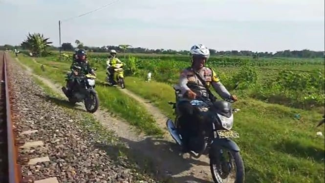 Petugas KAI dibantu TNI dan Polisi berpatroi di jalur rel.
