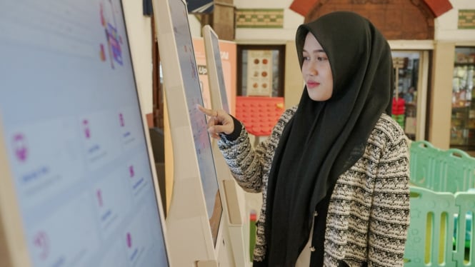 Calon penumpang kereta api memesan tiket di stasiun.