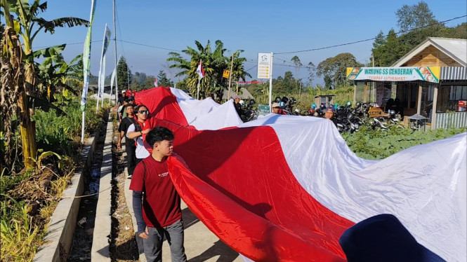 Bendera raksasa dibawa warga menuju puncak Gunung Andong.