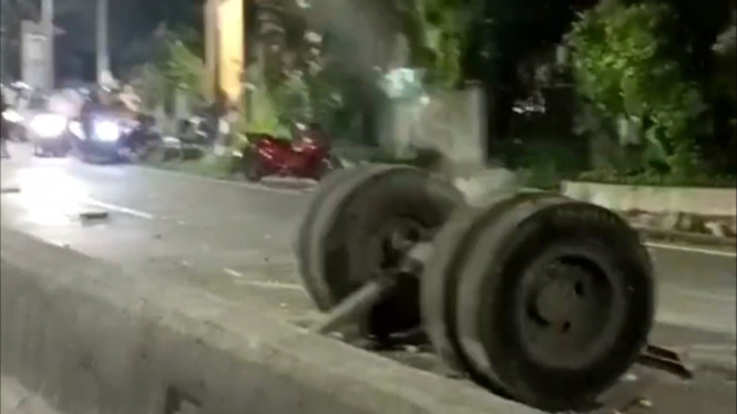 Roda truk beserta rangkanya terlempar ke tengah jalan.