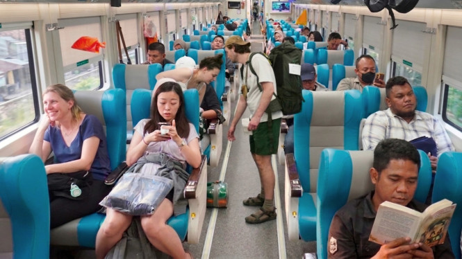 Wisatawan mancanegara menikmati perjalanan dengan kereta api.