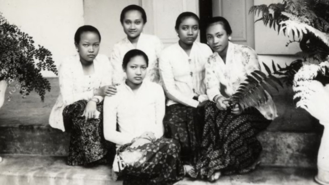 Perempuan Jawa di masa lalu sedang berpose di teras rumah.
