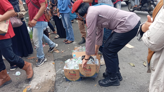 AKP Sulastri Membantu Membersihkan Sampah Sisa Aksi Unjuk Rasa