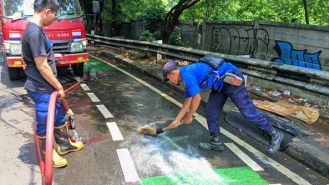 Petugas Damkar Depok bersihkan ceceran minyak di Jalan Juanda