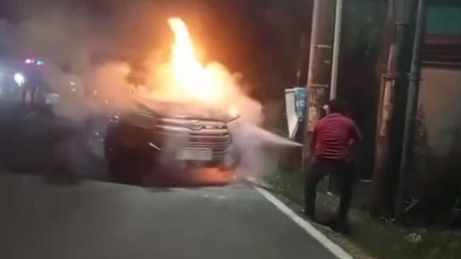 Seseorang Melakukan Pemadaman Terhadap Mobil Terbakar