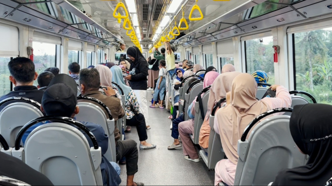 Penumpang padati gerbong kereta api.